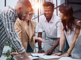 Cheerful colleagues discussing project in modern office