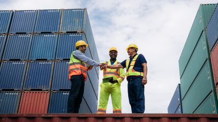 Team worker stack hand and shake hands to show success work at Container cargo harbor. Logistics concept inside the shipping, import, and export industries.