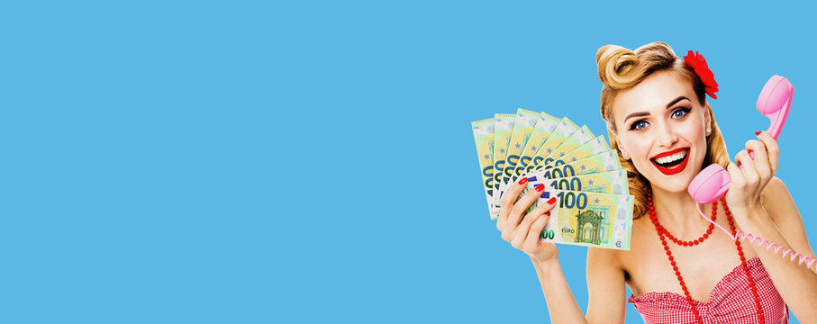 Photo Of Happy Excited Woman Holding Money Euro Cash Banknotes, Talking On Phone, Dressed In Pin Up Style. Blond Girl In Retro Fashion And Vintage Concept. Isolated Over Bright Blue Background.