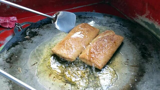 Cinematic shot. The making process of savory pan-fried pastry famously known as Martabak Telor stuffed with eggs, meat and onion leaf. One of the well known Indonesian Culinary cuisine