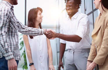 young businessman shaking hands with a colleague in the corridor