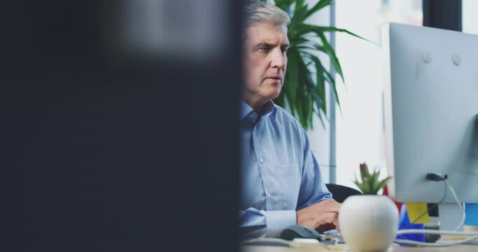 Senior man, business typing and computer in office with working and online work. Serious, ceo and mature manager doing digital research for analytics project with data reading and writing analysis