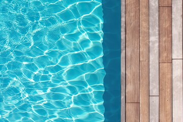 Fototapeta na wymiar Poolside paradise. Top view of an empty outdoor pool with wooden board on beautiful relaxing background
