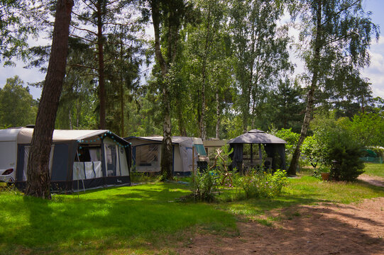 Wohnwagen mit Vorzelten auf einem schattigen Waldcampingplatz unter Birken und Kiefern, Gorinsee, Wandlitz, Brandenburg, Deutschland