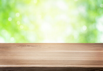Empty wooden table or shelf over green blurred nature background. Summer background with empty...