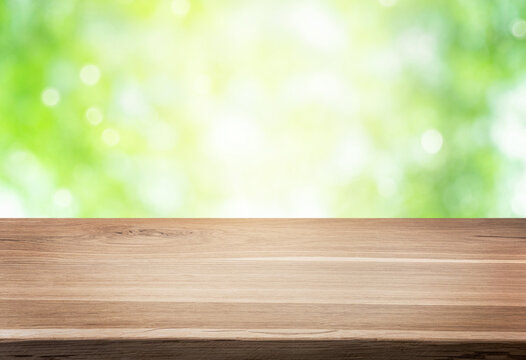 Empty wooden table or shelf over green blurred nature background. Summer background with empty space for product display