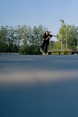 sporty girl rides roller skates in park on city background Active girl in enjoys roller skating...