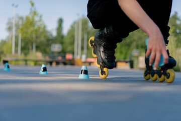 sporty girl practicing tricks on roller skates in park on city background enjoying roller skating lesson with chips close-up of street sport