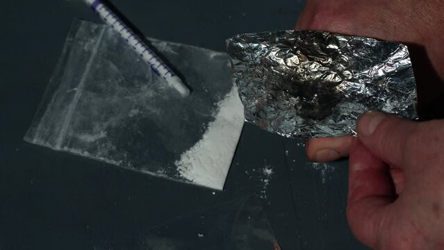 Drug addict burning heroin in foil