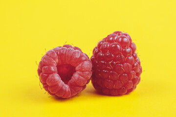 Fresh ripe and sweet raspberries on yellow background. Red raspberries. Macro shot.