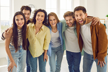 Group of happy smiling funny friends students or colleagues in casual clothes standing together,...