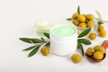 Natural spa.Olive natural cream and olive berries on a light textural background.Olive cream for hands, body and face. Concept of natural ingredients in cosmetology for gentle skin care.Spa care.