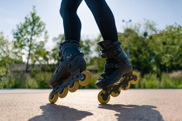 sporty girl practicing tricks on roller skates in park on city background enjoying roller skating lesson close up legs street sport