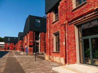 Modern cafe workspace exterior loft style red brick wall Old industrial building renovation. Creative urban space Break-out area city loft conversion brickwork warehouse design floor-to-ceiling window