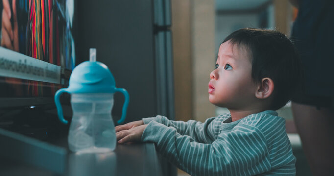 Portrait Of Asian Baby Boy Staring, Watching Television In Dark Room At Home. Innocence, Little Child Concentrate Looking Monitor.