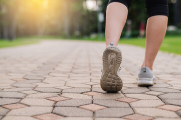 jogger woman. close up person training sport runner young female shoe on walk path in public park....