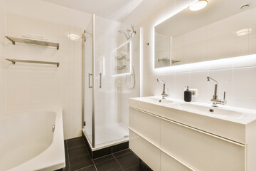 a modern bathroom with black tile flooring and white tiles on the walls, along with a freestanding shower