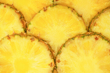 Pineapple juicy yellow slices as a background.