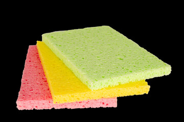 Three colored cellulose kitchen sponges, macro, isolated on black background.