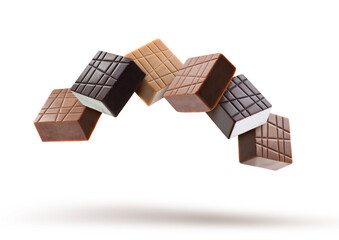 Assorted chocolate pralines floating on white background