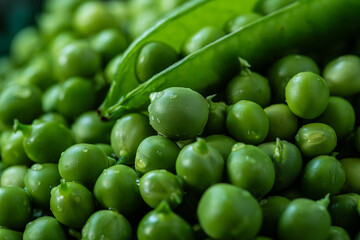 Heap of fresh green peas with open pod on the  top.