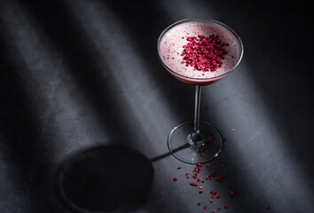 Pink cocktail with foam and dried beetroot powder as garnish