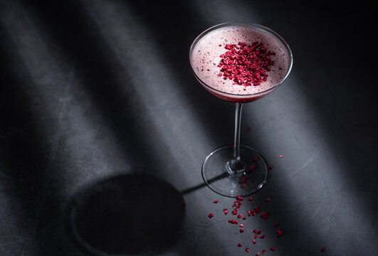 Pink cocktail with foam and dried beetroot powder as garnish