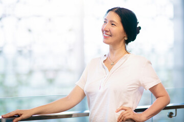 Young Asian woman indoors. Girl at big window.