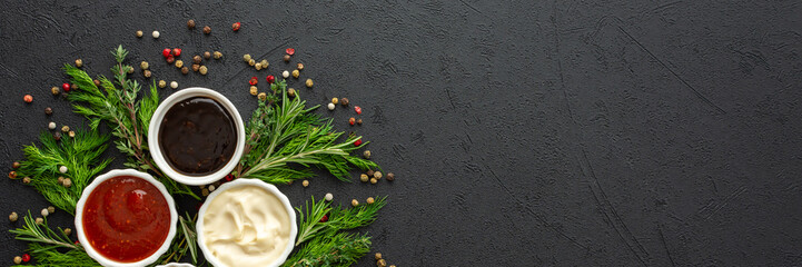 Different types of sauces in bowls with seasonings banner, rosemary and dill, thyme and and peppercorns, top view, copy space - obrazy, fototapety, plakaty