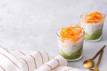 Healthy breakfasts and lunches, avocado and yogurt with chia, grated carrots and radishes in glass...