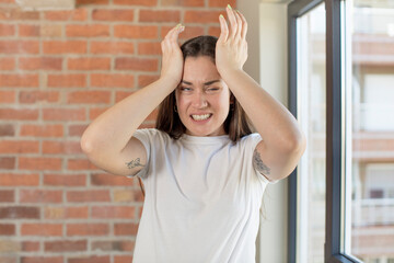 young adult pretty woman panicking over a forgotten deadline, feeling stressed, having to cover up a mess or mistake