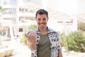 Obraz premium handsome man feeling happy, successful and confident, facing a challenge and saying bring it on! or welcoming you