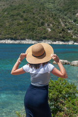 Fototapeta premium A young woman is looking at the sea while on vacation