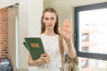 looking serious showing open palm making stop gesture. university student