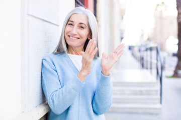 Fototapeta premium senior retired pretty white hair woman feeling happy and successful, smiling and clapping hands, saying congratulations with an applause