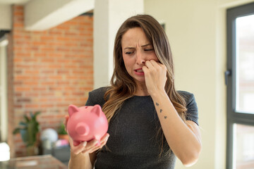 pretty woman feeling scared, worried or angry and looking to the side. piggy bank