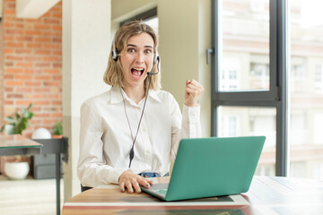 pretty woman feeling shocked,laughing and celebrating success. telemarketer concept