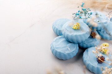 Handmade light blue soap with flowers on fabric, close-up