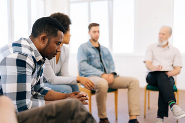 Closeup face of pensive sad african american man discussing alcohol addiction at therapy session....