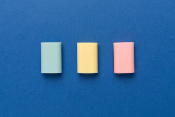 Colorful eraser on color backgroung, top view