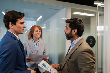 Group of workers reviewing the reports in the corridors of the coworking. Concept: business, work meeting, entrepreneurs