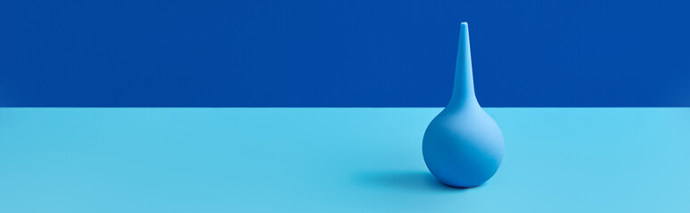 Blue rubber enema on table with copy space. Medical treatment concept