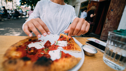 Young woman eating a pizza outdoor