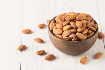 Raw peeled almonds in brown bowl