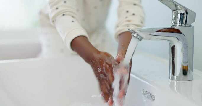 Hygiene, closeup and girl washing her hands with water and soap in the bathroom of her home. Health, self care and zoom of a child cleaning her skin to prevent germs, bacteria or dirt virus.