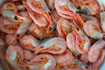 Close up on boiled big sea prawns or shrimps on glass plate. seafood, dieting food. Seafood on the counter. Photo of shrimp in the supermarket. Wholesale of fish. Frozen shrimp