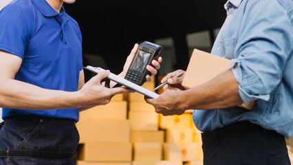 Asian delivery man in cargo van checking boxes. © ARMMY PICCA