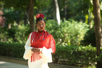 Young black woman dressed as a flamenco dancer stands in a famous park next to a duck pond in...