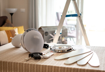 Accessories on the table ready to be assembled to install a paddle fan on the ceiling of the living room - obrazy, fototapety, plakaty
