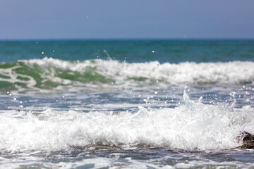 Sea waves with foam rolling onto the shore